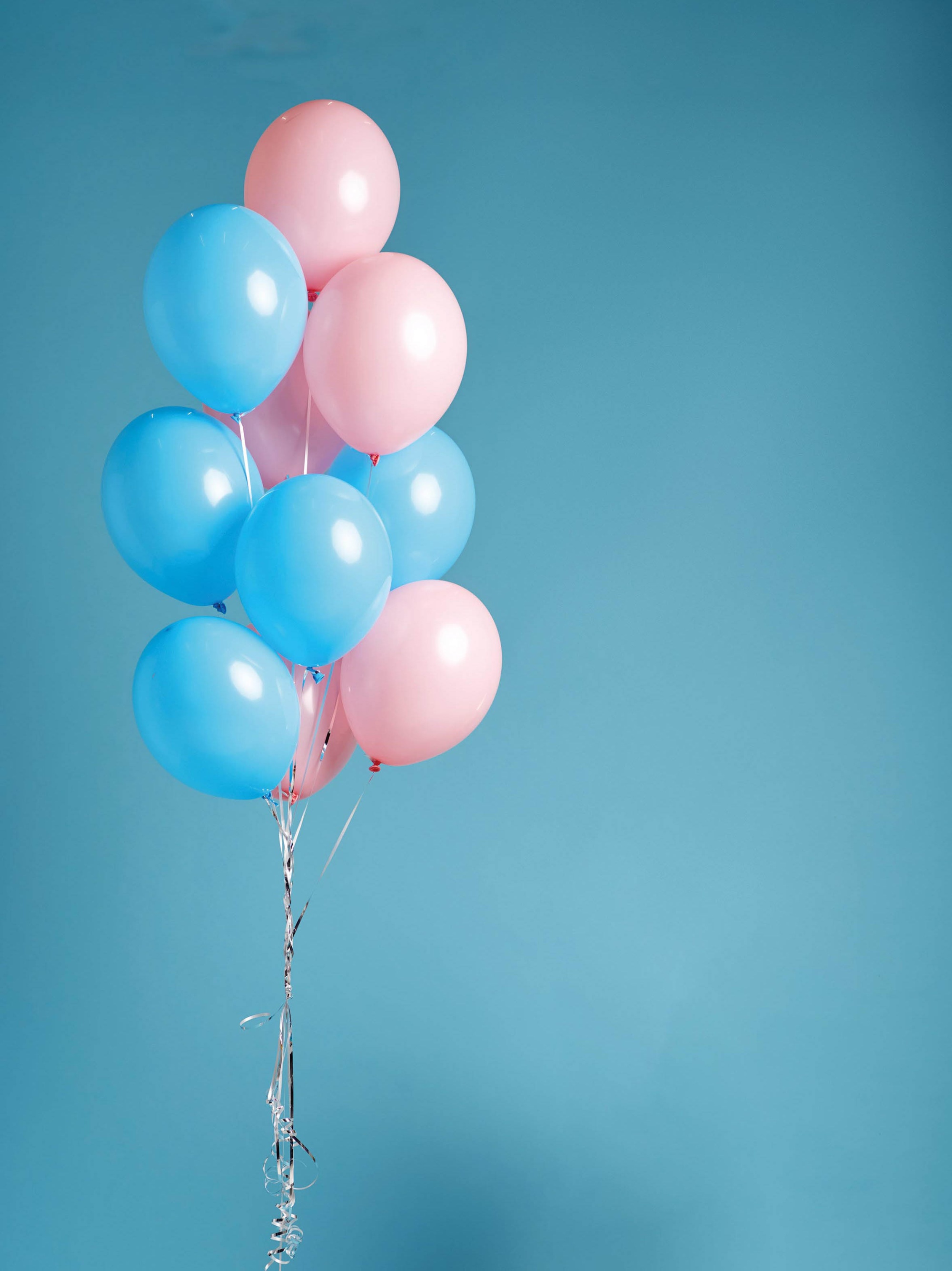 Funny little girl in cap holds a bunch of balloons