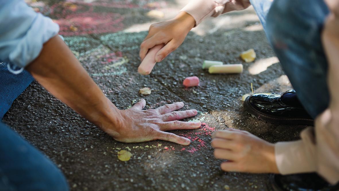 Kind malt Umriss um Erwachsenenhand