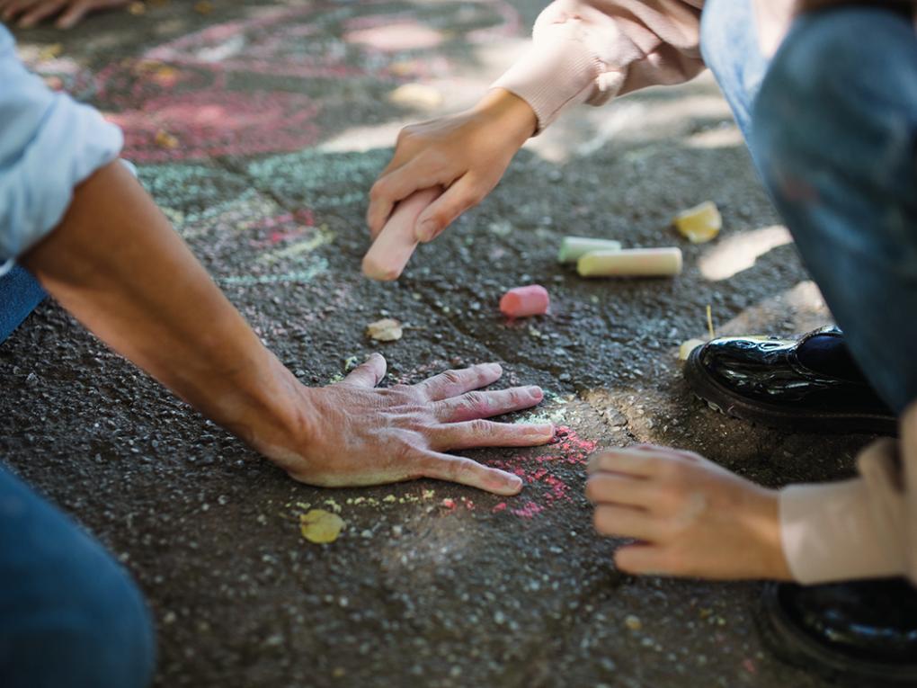 Kind malt Umriss um Erwachsenenhand